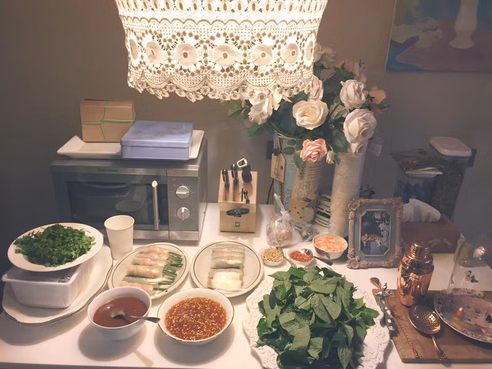 Bàn ăn đơn giản, được trang trí bằng một lọ hoa và tạo điểm nhấn bằng chiếc đèn chùm cổ điển lãng mạn.