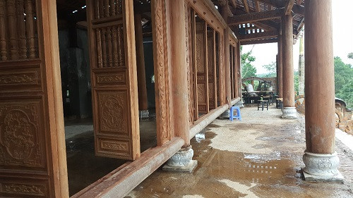 5 cánh cửa gỗ trổ ra khoảng hiên rộng vài chục mét vuông, nối với khu bậc lên xuống khoảng trên 20 bậc đang được lát đá hoa cương dở dang… Ảnh: Dân Việt.