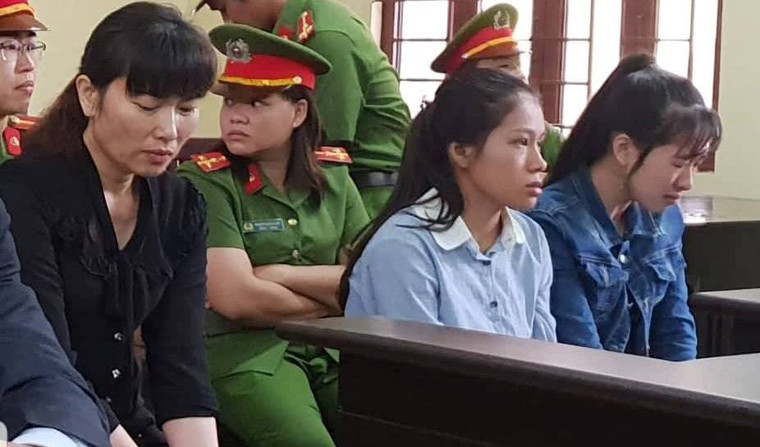 Đứng trước phiên tòa, bị cáo Linh (chủ cơ sở, áo đen) không giữ được bình tĩnh khi liên tục bật khóc nức nở, nhìn về phía những người nhà của các bé trong phòng xử.