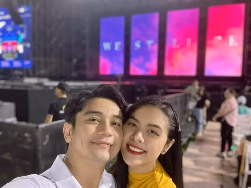 Vợ chồng Vân Trang tình tứ dưới hàng ghế khán giả. Ảnh: FBNV.