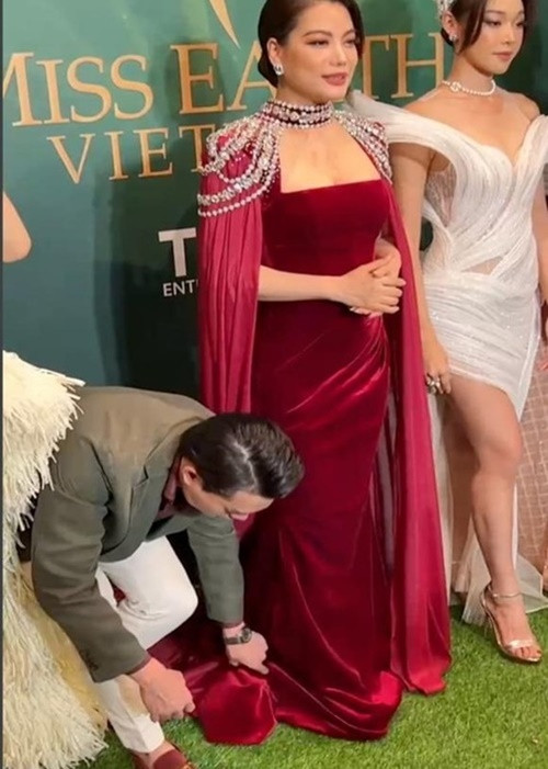 Nam diễn viên cúi người chỉnh trang phục cho bạn gái trên thảm đỏ sự kiện hồi tháng 7. Ảnh: Thương Hiệu Và Pháp Luật.