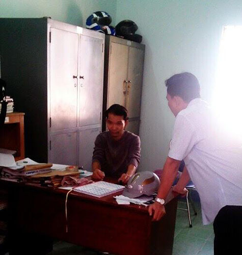 Nguyễn Ngọc Hồng (người ngồi) tại cơ quan công an.