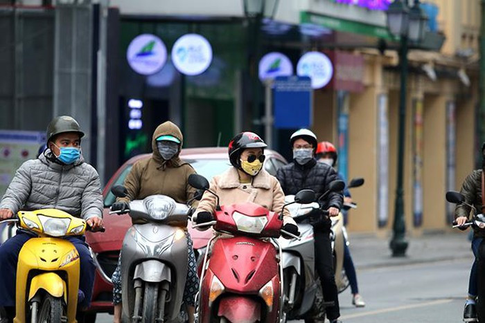 Mọi người có việc khi ra ngoài đường đều thực hiện việc đeo khẩu trang. (Ảnh: TTXVN).