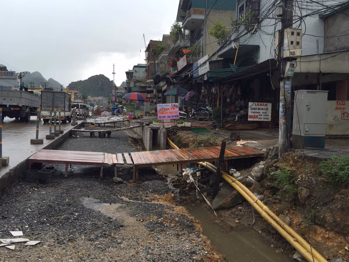 Trong khi các đơn vị thi công đang triển khai thực hiện dự án, cuộc sống người dân ở phường Quang Hanh (TP Cẩm Phả, tỉnh Quảng Ninh) đang bị ảnh hưởng. Họ phải chịu cảnh bắc cầu khỉ để đi vào nhà với nhiều rủi ro. Trời nắng thì bụi mù mịt, mưa thì ngập úng nặng.