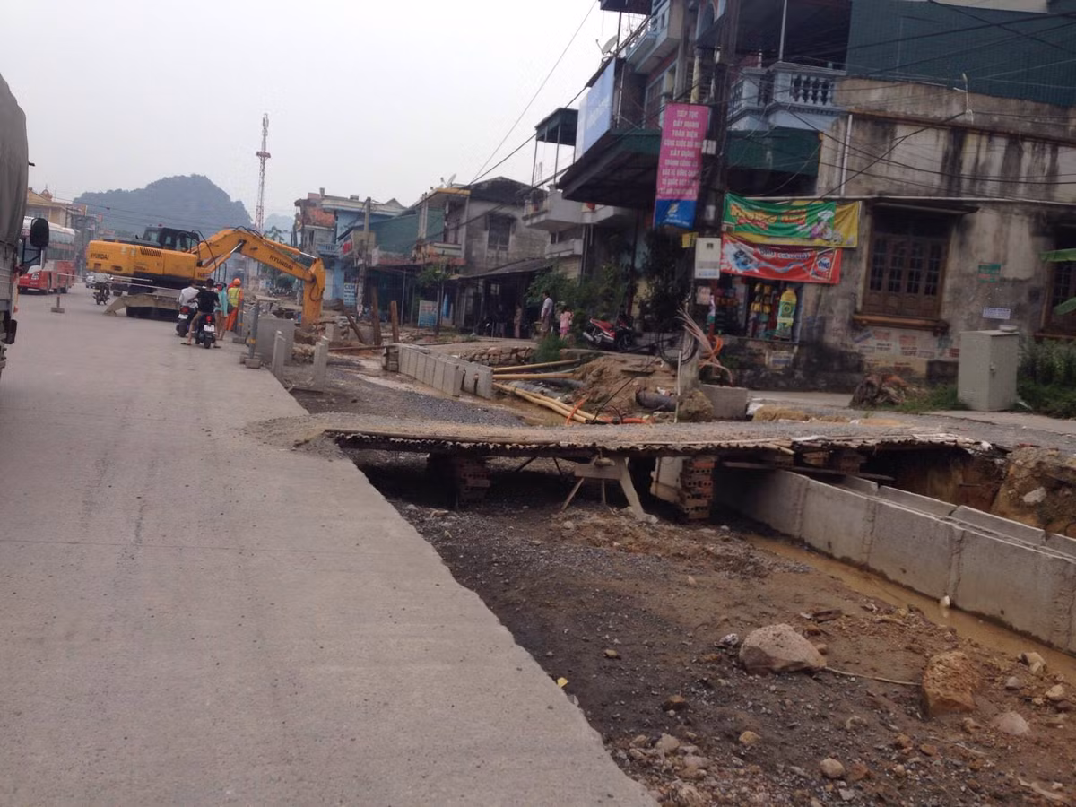 Những cây cầu bắc tạm từ quốc lộ 18 vào nhà các hộ dân ọp ép thô sơ, chỉ cần sơ ý có thể ngã xuống dưới.