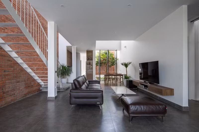 Trục giao thông trong nhà được KTS tổ chức theo chiều ngang của các không gian phòng khách, bếp và khu vực bàn ăn.