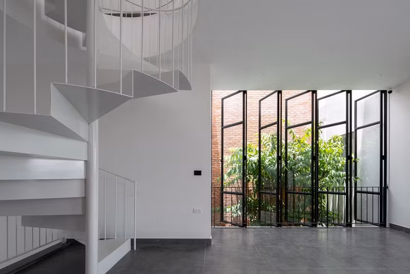 Những hệ cửa mở ra các khoảng vườn cũng được thiết kế ở tầng hai để lấy nguồn gió tự nhiên vào nhà.