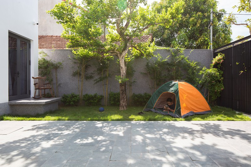 Sự lồng ghép cây xanh này giúp không gian thêm phần thanh bình và thoáng mát, các con của gia đình có nơi vui chơi thậm chí cắm trại trên mảnh sân vườn phía trước.