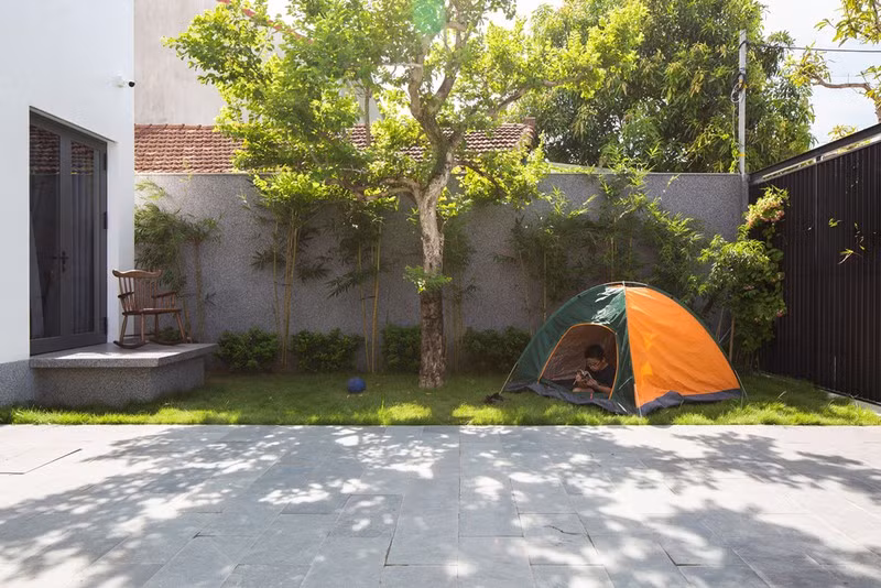 Sự lồng ghép cây xanh này giúp không gian thêm phần thanh bình và thoáng mát, các con của gia đình có nơi vui chơi thậm chí cắm trại trên mảnh sân vườn phía trước.