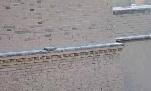 Không tin vào điều này, viên quan phụ trách công trình bỏ viên gạch xuống. Bất ngờ, một đoạn tường thành đổ sập và phải xây lại. Sau khi hoàn thành, viên gạch được đặt lại vị trí cũ. Kể từ đó đến nay, viên gạch vẫn nằm nguyên vị trí, không bị xê dịch.