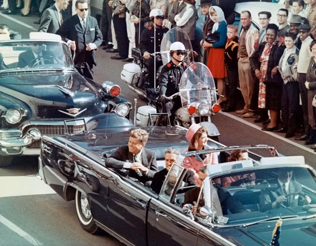 Vào ngày 22/11/1963, Tổng thống Kennedy bị ám sát khi đi vận động cử tri trên một chiếc xe mui trần tại thành phố Dallas, bang Texas. Thủ phạm gây ra vụ ám sát là Lee Harvey Oswald.