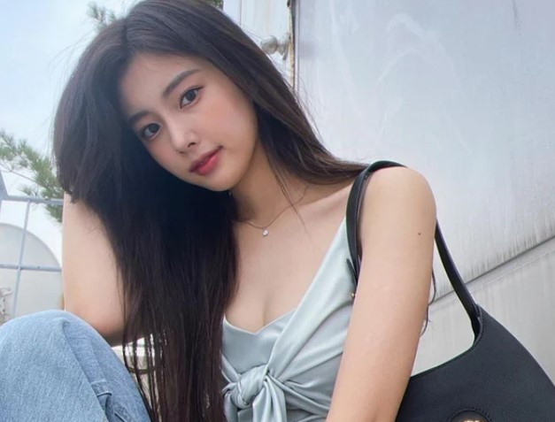 Hye Won (IZ*ONE) diện mẫu áo dây có kiểu dáng thú vị với hai tà áo cột thành nơ trước ngực, nữ idol điểm xuyến cho outfit bằng dây chuyền dây mảnh tinh tế cùng túi xách đen. Cô nàng trông vừa đơn giản mà vẫn đảm bảo sự cá tính.