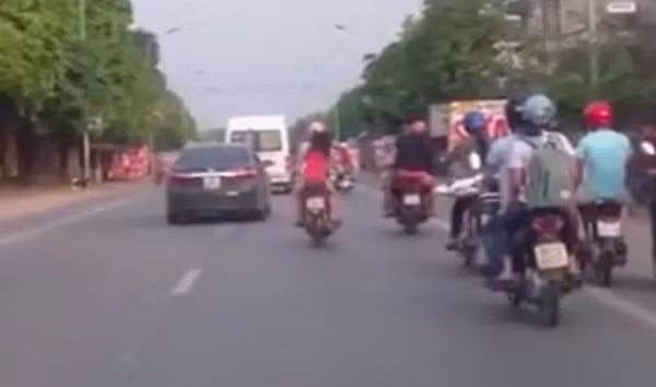 Người phụ nữ đèo trẻ em vẫn phóng nhanh vượt ẩu. Ảnh cắt từ clip.