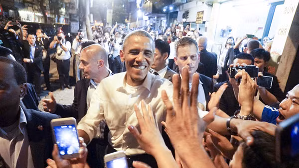 Trong chuyến thăm Việt Nam, ông Obama gây thiện cảm về sự gần gũi, cởi mở, hòa đồng với người dân. Ông đi ăn bún chả bình dân, vui vẻ chụp ảnh, bắt tay người hâm mộ. Ảnh: Dân Trí.