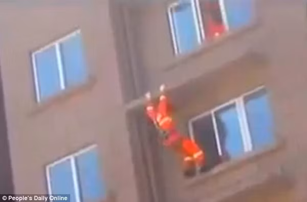 Lính cứu hỏa đạp mạnh cho cô gái ngã vào phòng để giải cứu. Ảnh cắt từ clip.