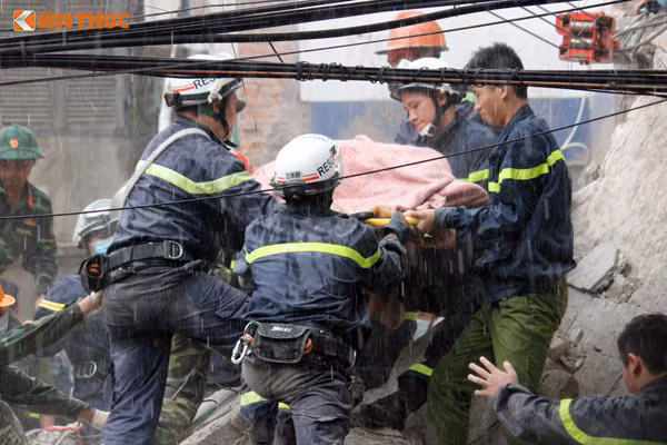 Lực lượng cứu hộ đưa nạn nhân tử vong ra khỏi hiện trường vụ sập nhà ở Hà Nội hôm 4/8. Ảnh: Bùi Hưng.