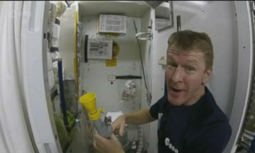 Phi hành gia đang hướng dẫn cách sử dụng toilet trong không gian.