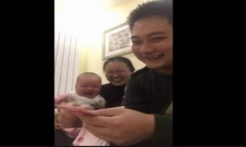 Hình ảnh em bé không ngừng cười khi nhìn ông bố đếm tiền.