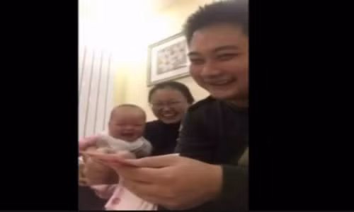 Hình ảnh em bé không ngừng cười khi nhìn ông bố đếm tiền.