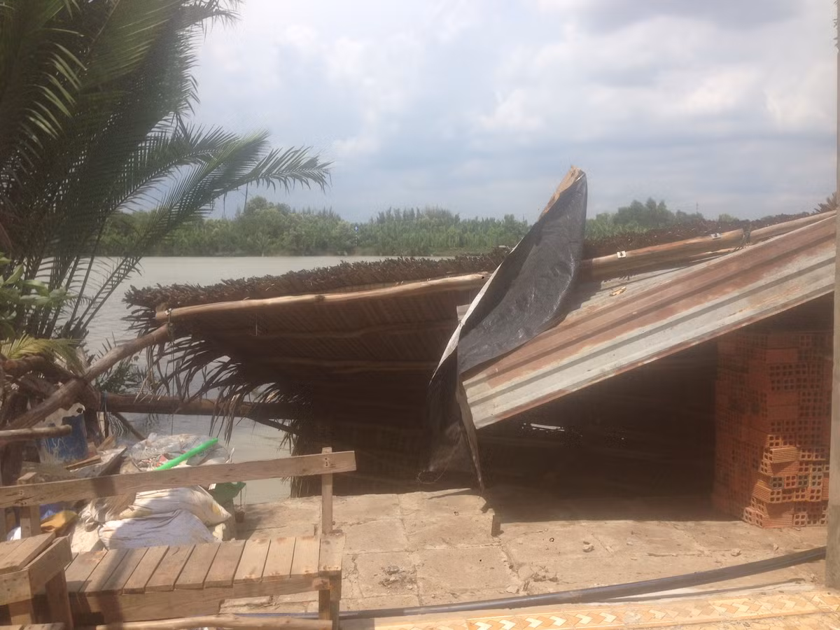 Phần mái tôn của một căn nhà mấp mé bên bờ sông.