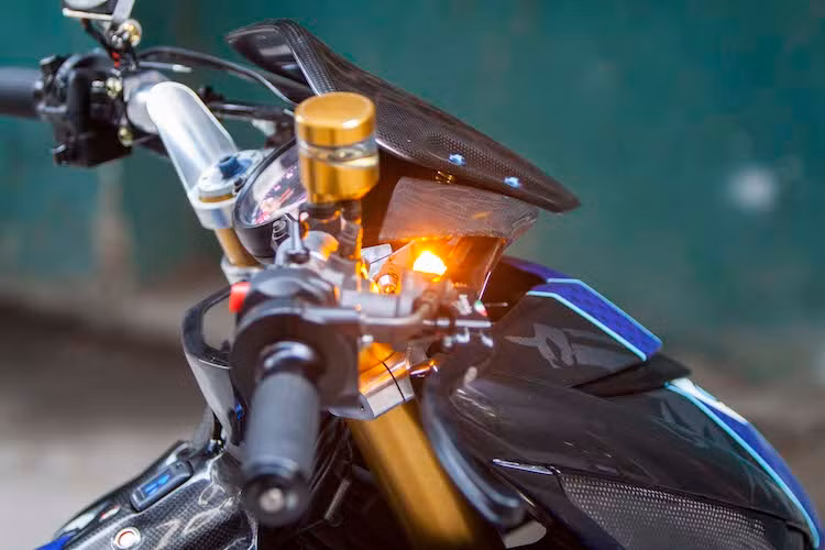 Nằm phía trên chảng ba của xe là bảng đồng hồ đa chức năng Koso RX2N, trong khi bên trên tay lái còn có thêm một đồng hồ Koso Mini 3 nhỏ. Khu vực tay lái của chiếc Exciter 150 độ khủng này cũng hội tụ nhiều món đồ chơi "hàng khủng" khác gồm cùm ga Domino, cùm phanh Brembo RCS, cùm côn CRG GP và bình dầu Rizoma.