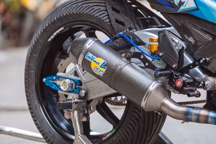 Để lắp vừa mâm Marchesini lớn ở phía sau, bộ gắp nguyên bản của Exciter 150 đã được thay bằng gắp BMW S1000RR, cùng với dè con bằng sợi carbon và bình dầu Nitron. Hệ thống phanh sau của xe cũng đã được nâng cấp triệt để với phanh Brembo Billet Nickel 2 pis đối xứng, đĩa Braking, pen đạp Brembo và bình dầu Rizoma.