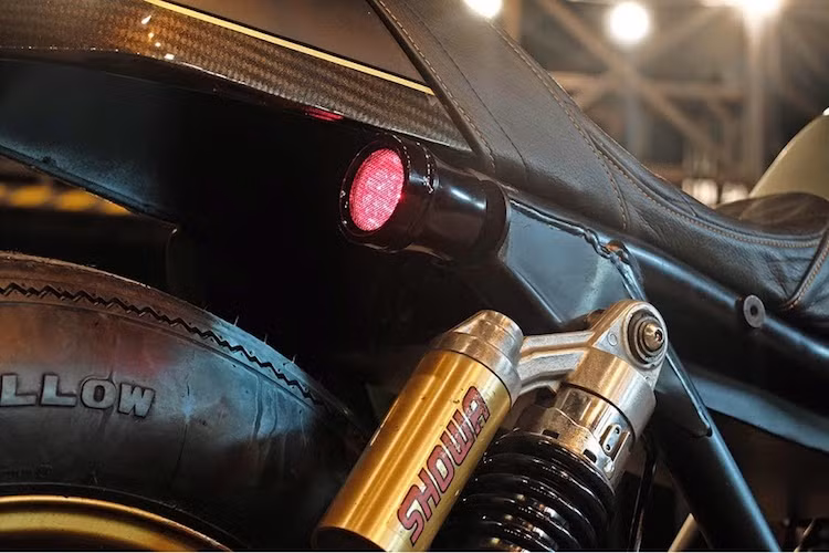 Ở phía sau, một đèn hậu LED của Bratzstyle được bố trí ở phía bên phải thân xe, gần bộ giảm xóc Showa nguyên bản. Lấy cảm hứng từ chiếc MV Agusta độ mang tên Ballistic Trident tới từ xưởng độ Rough Crafts ở Đài Loan, chiếc xe cũng được phối tông màu đen-vàng và trang trí bởi các đường viền dán decal carbon 6D.