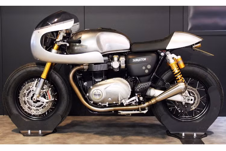 Bình xăng nguyên bản của Thruxton R vốn đã có thiết kế rất đẹp mắt, chính vì vậy Down &amp; Out chỉ sửa đổi bằng cách tẩy sơn màu, đánh bóng và phủ sơn bóng bảo vệ. Nằm bên trên bình xăng là một dây đai da lấy từ chiếc áo khoác của hãng độ Barbour International.