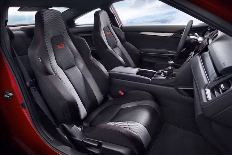 Thay đổi dễ nhận ra nhất của Civic Si bên trong nội thất đó là cặp ghế ngồi trước thể thao với các đường chỉ đỏ tương phản cùng bệ cần số bọc da và tay nắm sô bằng nhôm. Khó nhận ra hơn một chút là các đường chỉ đỏ tương phản thêu trên ốp cửa, vô-lăng và bộ pedal thể thao bằng nhôm với vân nổi chống trượt chân.
