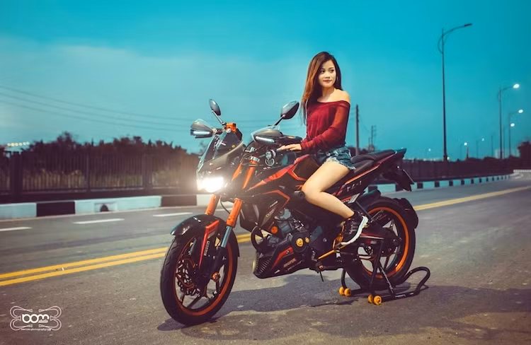 Sau khi được độ lại, chiếc FZ150i đã trở nên "ngầu" hơn với kiểu dáng mang phong cách Kawasaki Z1000. Chiếc xe càng trở nên hấp dẫn hơn khi có bóng dáng của người đẹp Việt bên cạnh.