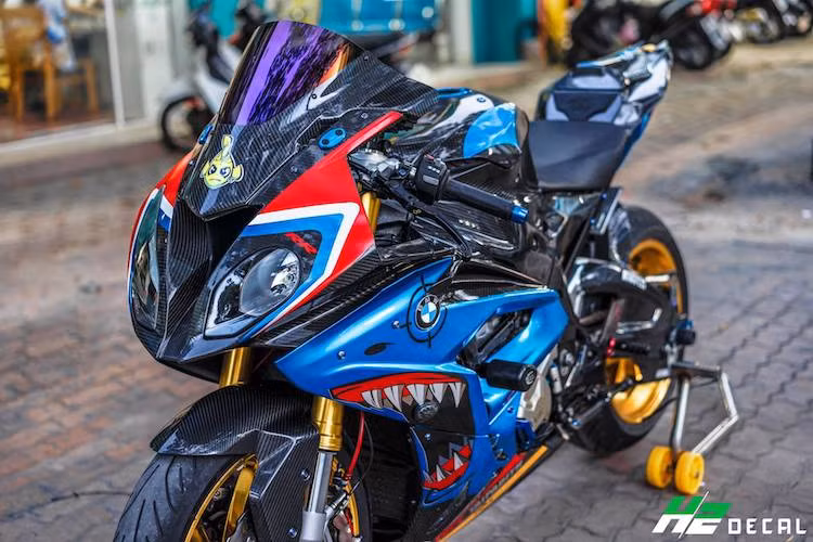 Trên nền dàn áo carbon, chủ xe đã dán trang trí chiếc S1000RR với hình ảnh của loài cá mập hai bên quây gió, tương xứng với biệt danh "cá mập" được nhiều biker Việt gọi chiếc xe. Trên khu vực tay lái là cùm côn và phanh Brembo RCS kèm tay Lightech, bình dầu Rizoma, bảo vệ tay phanh Lightech trong khi bên dưới là cặp chống đổ của R&amp;G.