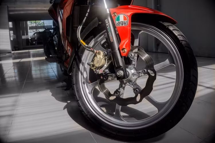 Thay vì cặp mâm nguyên bản 6 cánh kép của chiếc xe côn tay Winner 150 vốn đã khá độc đáo và thể thao, chủ xe đã trang bị mâm 6 cánh đơn mới thể thao hơn. Nhằm tăng độ an toàn khi đi trên đường, hệ thống phanh trước được nâng cấp với đĩa Galfer và heo Brembo 2 pis đối xứng, được chế vào phuộc xe bằng pad nhôm CNC.