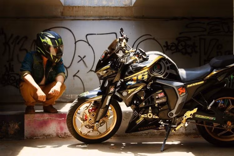 "Dàn chân" trước của chiếc xe đã được chủ nhân độ lại với mâm Asio 5 cánh kèm lốp 120/70/17. Gắn trên bánh trước là đĩa hoa đi kèm với heo Brembo. Vỏ phuộc nguyên bản của chiếc Yamaha FZ-S đời cũ trông khá yếu do có đường kính nhỏ cũng được chủ xe cải thiện bằng vỏ ốp ngoài.