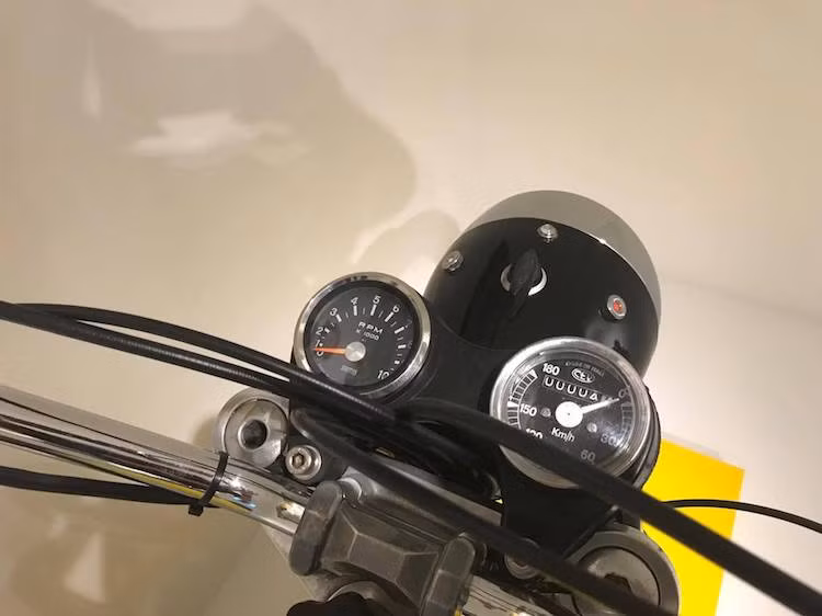 Theo phong cách scrambler, ngay từ thế hệ đầu tiên Ducati Scrambler đã được trang bị ghi-đông bằng thép mạ bóng cao và rộng, đem tới tư thế thoải mái cho đôi tay của người điều khiển. Nằm phía trên tay lái là 2 đồng hồ báo tua và báo tốc độ đơn giản. Trong đó đồng hồ báo tốc có mặt lộn ngược khá độc đáo.