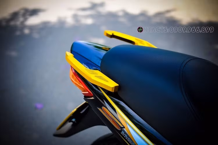 Phần tay xách nguyên bản của WAve S đã được thay bằng cặp tay CNC nhôm màu vàng bắt mắt ở phía sau. Trong khi đó, bộ yên nguyên bản được "gọt đẽo" lại để khiến yên cho người ngồi sau cao hơn hẳn so với người lái giống như nhiều mẫu xe sportbike.