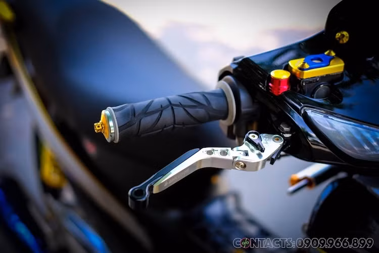 Ở phía trên tay lái của xe là các món đồ chơi như tay phanh Biker có khả năng điều chỉnh tự do cùng cặp bao tay Spider gel mềm hạn chế rung tay. Ngay cả các chi tiết nhỏ nhất như nắp bình dầu hay chân ốc bắt gương chiếu hậu cũng được chủ xe thay bằng các món "đồ chơi" bằng nhôm nhuộm màu vàng kim loại bắt mắt.