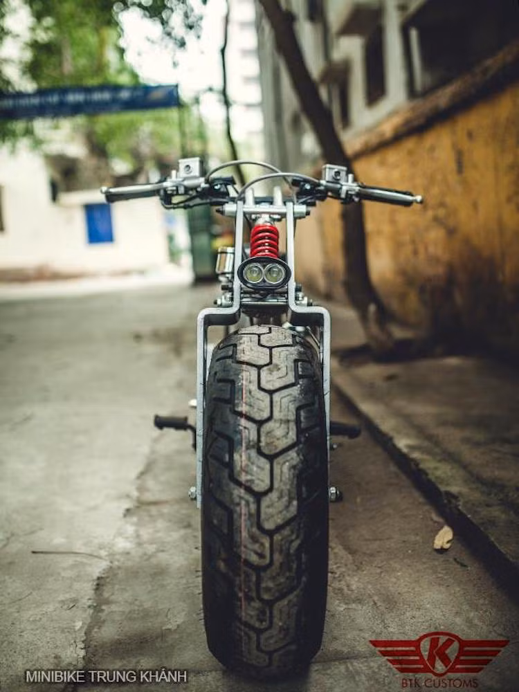 Thay vì phanh đùm nguyên bản, chiếc xe đã được trang bị hệ thống phanh đĩa bố trí gọn gàng trong lòng mâm lớn. Ở phía trước, một đèn LED nhỏ đóng vai trò là đèn pha cho chiếc xe, nằm ngay phía trước kết cấu phuộc đơn đậm chất "cơ khí".