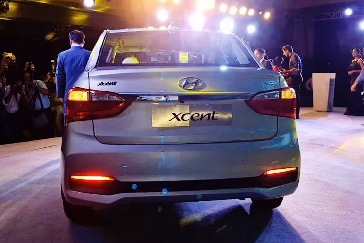 Bên cạnh phần đầu, đuôi xe cũng được thiết kế lại khá triệt để. Không còn sử dụng chung đèn hậu với phiên bản hatchback, Xcent 2017 được trang bị cặp đèn hậu mới kéo dài về hai bên thân xe, khiến phần đuôi xe giống "đàn anh" Elantra hơn. Đi kèm với đèn hậu mới, nắp khoang hành lý và cản sau cũng được thiết kế lại.