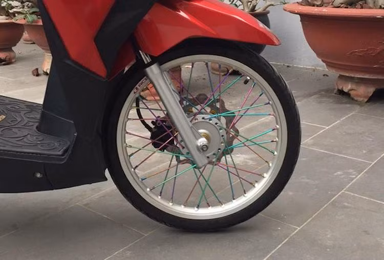 Ở dạng nguyên bản, Click 125i sử dụng vành đường kính 14 inch 5 cánh kép đẹp mắt nhưng trông khá "trống". Chính vì vậy, chủ xe đã thay hoàn toàn cặp vành đúc này bằng niềng nhôm 17 inch bản nhỏ, kèm theo bộ nan hoa 7 màu theo đúng phong cách kiểng Thái, khiến dáng của Click 125i trở nên nhẹ nhàng và cân đối hơn.