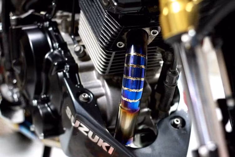 Vốn được đánh giá coa bởi giới chơi xe Việt từ lâu, khối động cơ 150 phân khối xi-lanh đơn DOHC của Satria 150 trên bản độ này không có sự thay đổi về kết cấu bên trong. Người chơi xe đã chỉ trang bị cho két làm mát dầu tấm bảo vệ bằng nhôm CNC và cổ pô titan khò ánh xanh đẹp mắt.