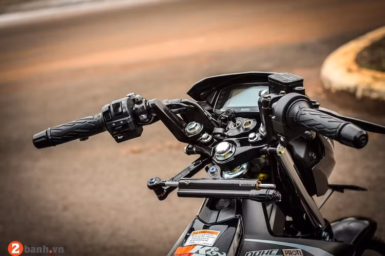 Ở phía trên khu vực tay lái, chiếc Satria F150 Fi không có thay đổi gì đặc biệt, ngoại trừ sự xuất hiện của cây trợ lực điện Ohlins vốn chỉ dành cho các dòng superbike.