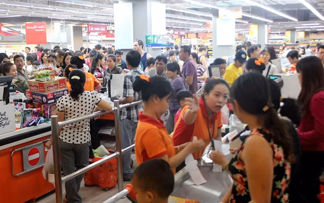 Nhân dịp khai trương, siêu thị giảm giá hàng trăm mặt hàng gia dụng và thực phẩm. Khách rất đông, phải xếp hàng chờ thanh toán. 
