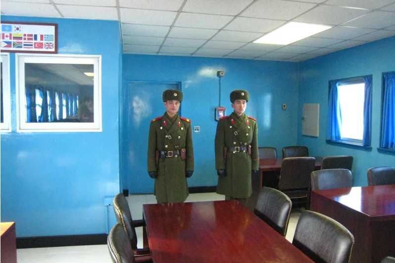 Lính Triều Tiên trong trang phục mùa đông bên trong một nhà xanh, họ đứng gác ở lối đi vào miền nam.