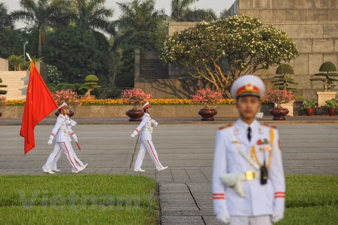 Dưới nhịp bước quân hành, cả đội hình tiến về phía cột cờ chính giữa Lăng Bác trong sự chăm chú theo dõi hàng trăm đồng bào và du khách quốc tế.