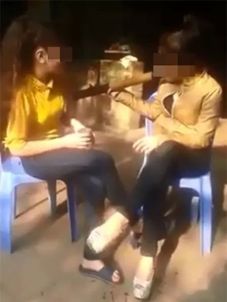 Hai cô gái ngồi trên ghế luân phiên hút thuốc lào và hát bài "Không say bin" từng một thời gân xôn xao cộng đồng mạng.
