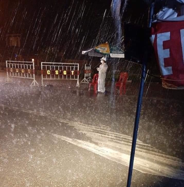 Thực tế đây không phải là lần đầu tiên xuất hiện hình ảnh các y bác sĩ không quản ngại thời tiết để hoàn thành nhiệm vụ. Khoảnh khắc ghi lại một người mặc đồ bảo hộ đang đứng trước chốt của địa điểm bị phong tỏa. Mặc dù trời mưa như trút nước nhưng người này vẫn kiên trì đứng trụ, cố gắng hoàn thành tốt nhiệm vụ của mình cũng làm nhiều người cảm động.