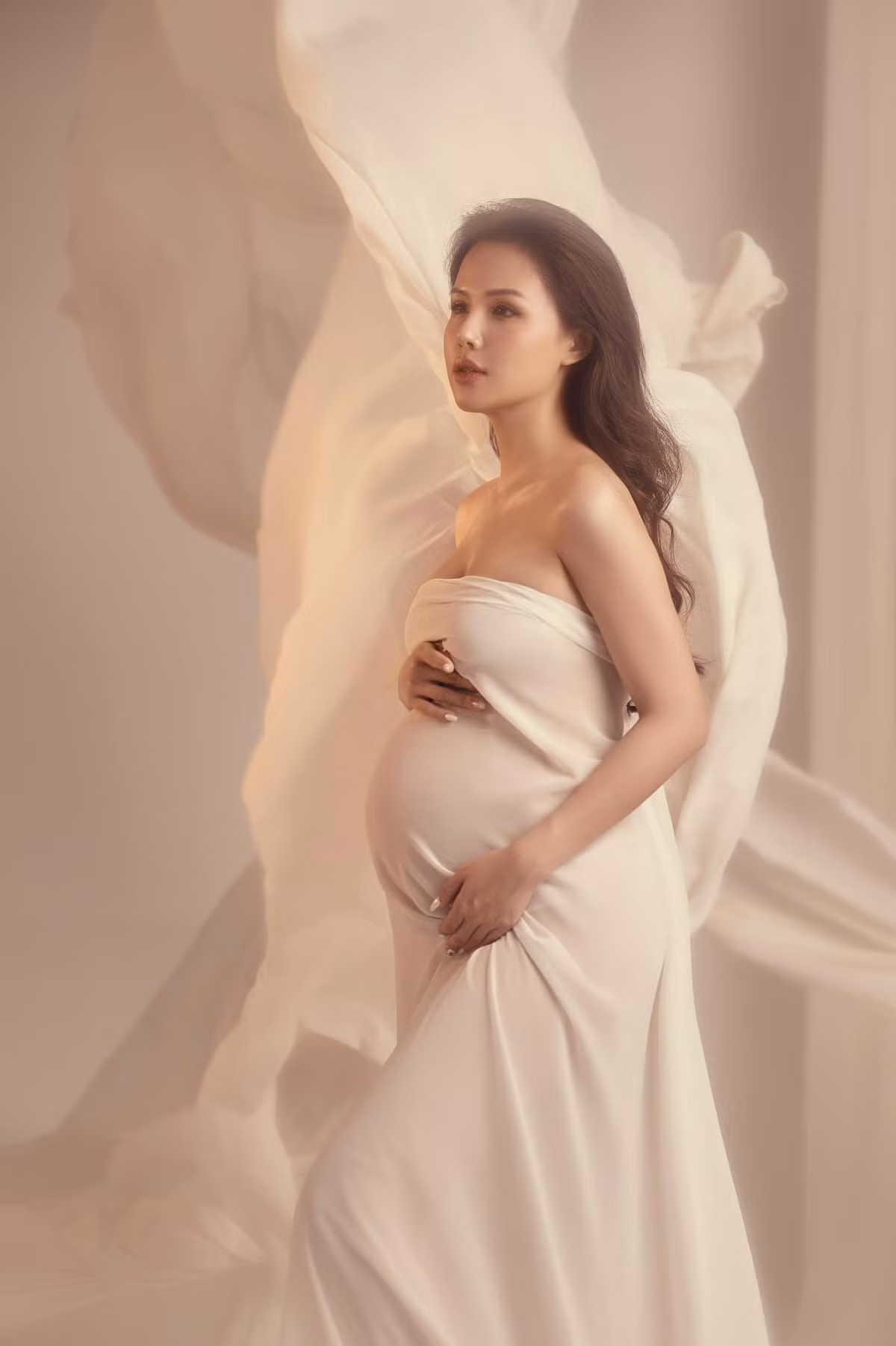 Quấn quanh người chiếc váy lụa mỏng, Phanh Lee làm tôn lên đường cong ý nghĩa của người phụ nữ trong giai đoạn mang thai.