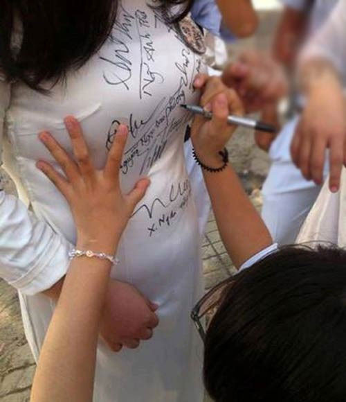 Thêm một hình ảnh phản cảm khi nữ sinh để bạn học động chạm vòng 1, ký tên lên áo dài.