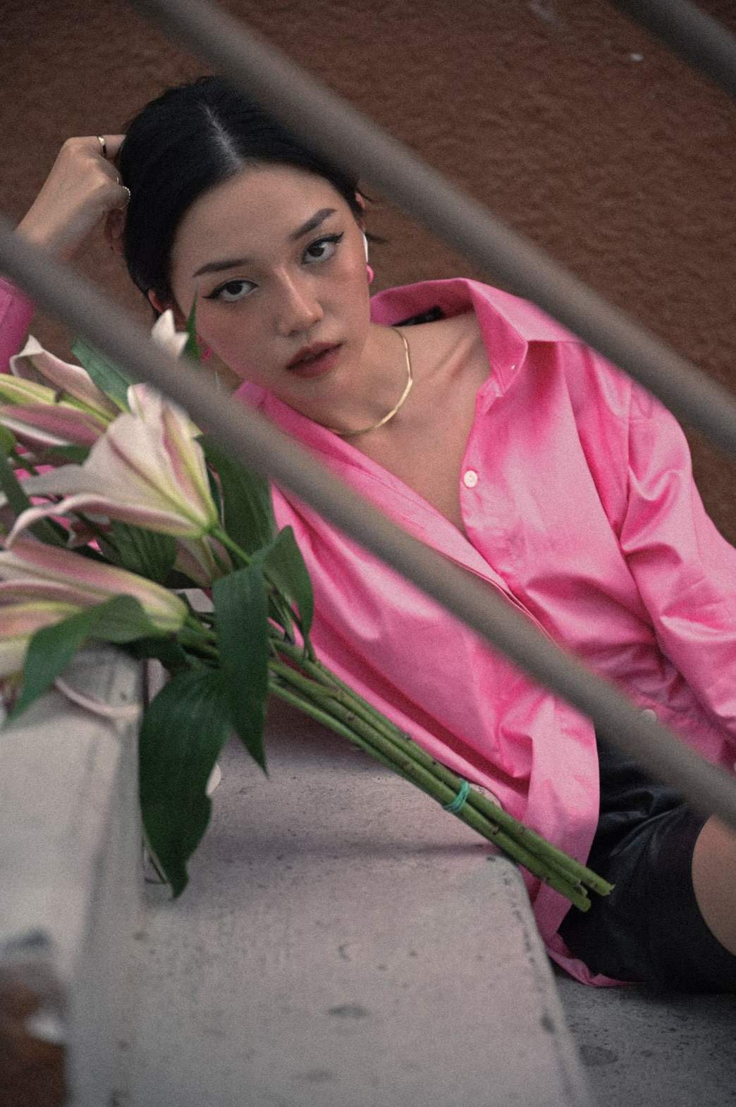 Diện áo dáng dài màu hồng và tạo dáng bên bó hoa ly, búi tóc thấp một cách khác lạ, Linh Ngọc Đàm đã cho ra đời bộ ảnh mang phong cách vintage thu hút sự chú ý.