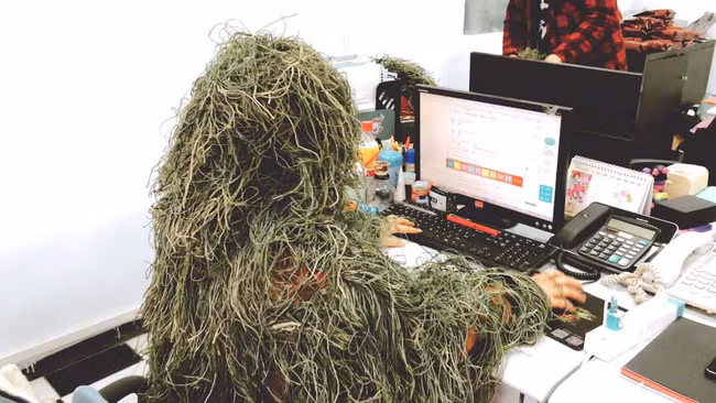 Thậm chí tới văn phòng làm việc chàng ta vẫn dũng cảm diện bộ đồ ngụy trang. Chẳng biết dùng từ gì để so sánh nữa, nhưng hình ảnh này quả thật gây cười. Đồng nghiệp xung quanh không trêu chọc mới lạ đấy! Những hình ảnh này sau khi đăng tải đã thu hút hàng chục nghìn lượt tương tác. Nhiều người phì cười đưa ra nhận xét: 'Y như hình, nhìn không nhận ra luôn á', 'Nhìn như cây lau nhà', 'Bộ đồ ẩn thân này có trốn được deadline không thì mua về mặc', 'Tôn Ngộ Không phiên bản ít lông à?', 'Thật cạn lời luôn ấy, nhưng hài hước thật sự'... Có thể bộ đồ này với các game thủ có ý nghĩa nhưng quả thật không phải cái gì từ game ra cũng có tính ứng dụng cao. Và như bộ đồ ngụy trang này thì đúng là một bầu trời tấu hài!